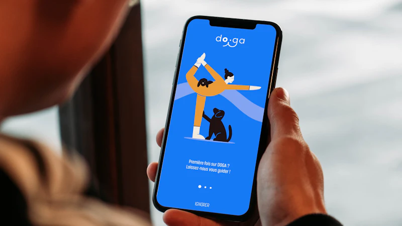 Person holding a smartphone with a yoga app open